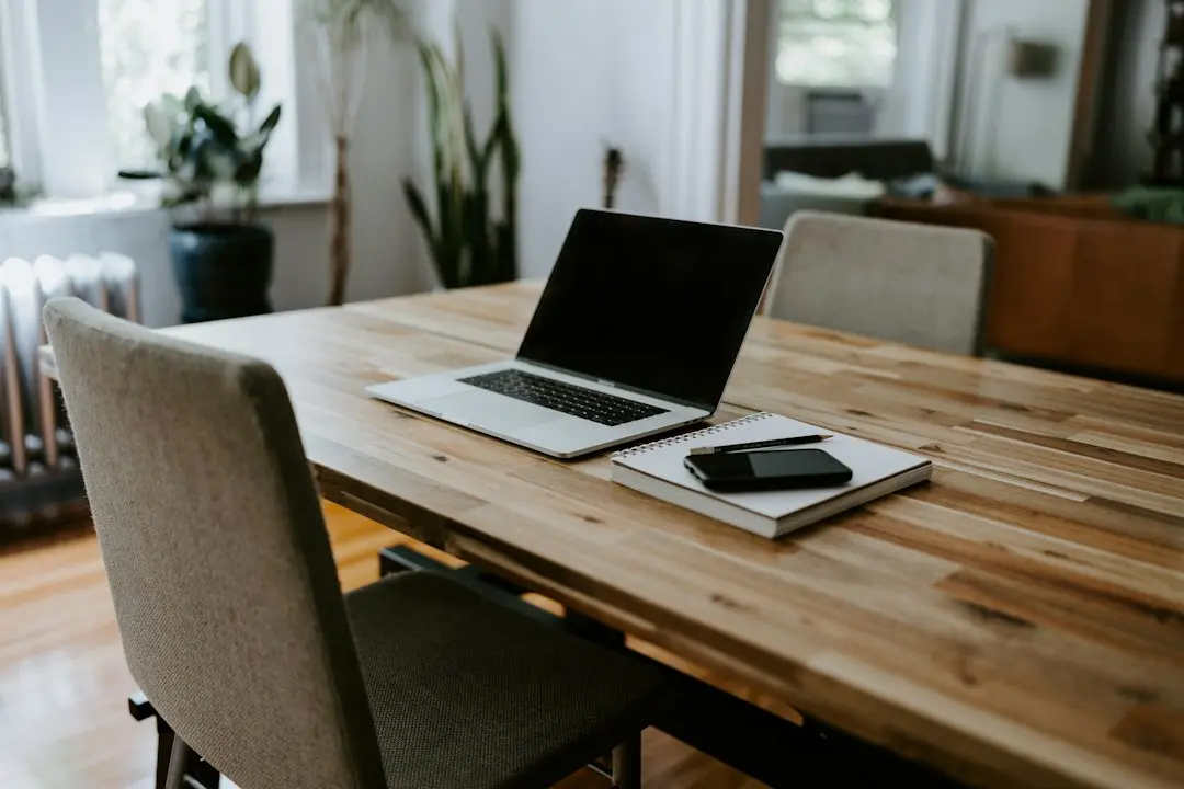 A laptop, a notebook and a smartphone on a wooden dining table, the kind of devices used with Nexus4kTV
